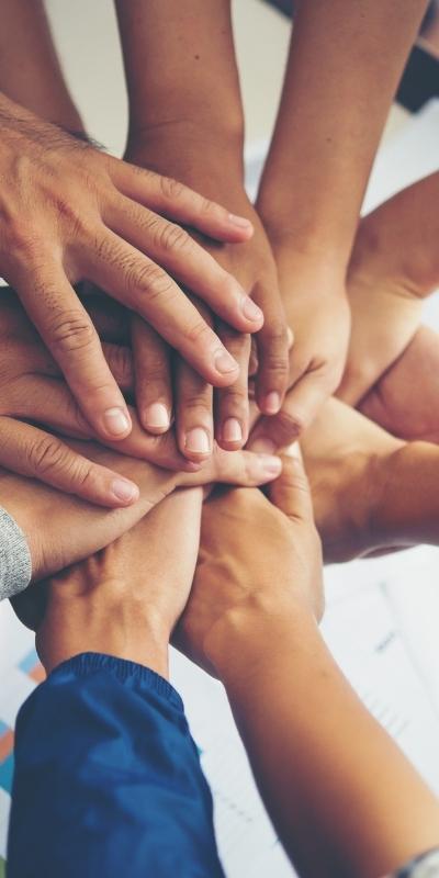 Flip Box Images-400x800 Image of people in circle putting hands in for teamwork